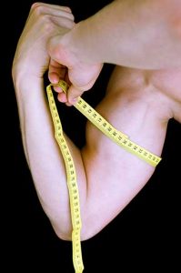 man-measuring-his-muscular-arm